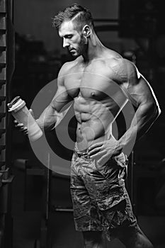 Muscular Man Resting After Exercise And Drinking From Shaker