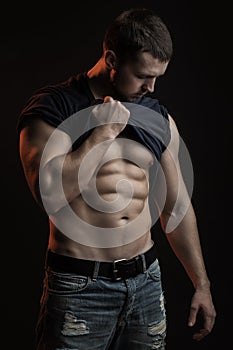 Muscular man with shirt on shoulder