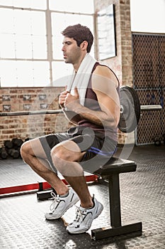 Muscular man sitting on bench