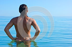 Muscular man standing in water