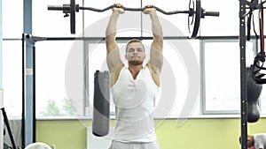 Muscular man on strength training in the gym. Athlete makes triceps exercise with a barbell