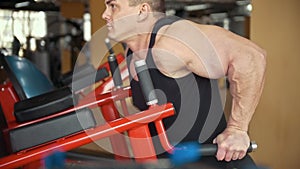Muscular man training his bicep in a gym