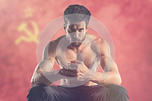 Muscular man with USSR flag behind