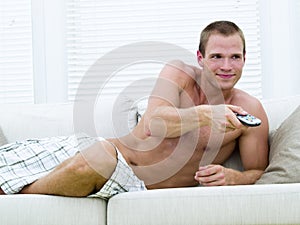 Muscular man watching TV