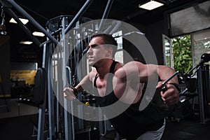 Muscular man working out at bodybuilding gym