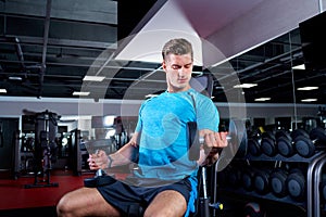 Muscular man working out with dumbbells in gym.