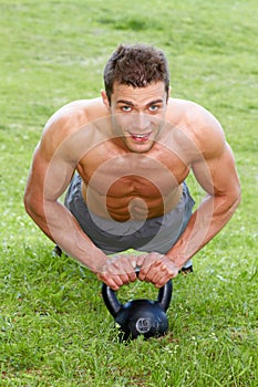 Muscular man working out on green grass