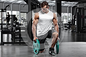 Muscular man working out in gym doing exercise, strong male bodybuilder