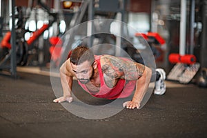 Muscular man working out in gym doing exercises.