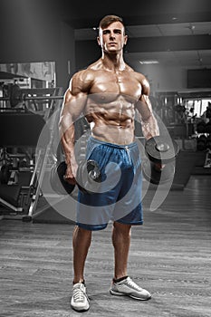 Muscular man working out in gym doing exercises with barbell, strong male naked torso abs