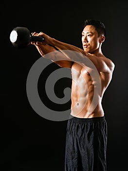 Muscular man working out with kettle bell