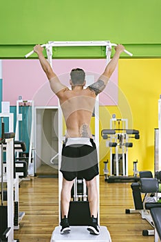 Muscular man workout doing pull ups on bar in gym,Man working out in a fitness club