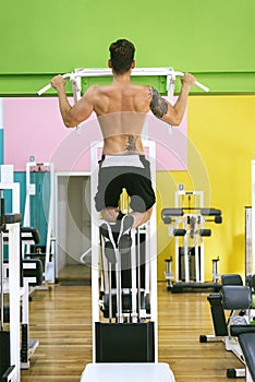 Muscular man workout doing pull ups on bar in gym,Man working out in a fitness club