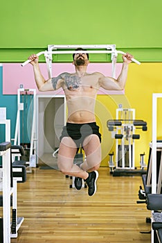 Muscular man workout doing pull ups on bar in gym,Man working out in a fitness club