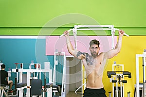 Muscular man workout doing pull ups on bar in gym,Man working out in a fitness club