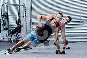 Muscular men doing a side plank