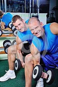 Muscular men exercising in a gym