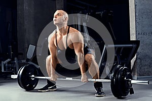 Muscular men lifting deadlift In the gym