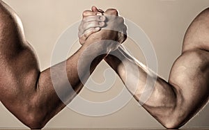 Muscular men measuring forces, arms. Hand wrestling, compete. Hands or arms of man. Muscular hand. Rivalry, closeup of