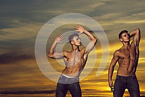 Muscular men in sunset with boxes