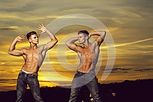 Muscular men in sunset with boxes