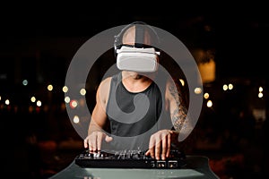 Muscular nightclub DJ in night vision glasses