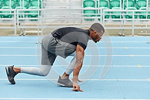 Muscular runner standing in the croach, low start