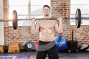 Muscular serious man doing weightlifting