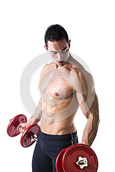 Muscular shirtless young man exercising biceps with dumbbells