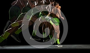 Muscular shirtless man is captured in motion, training, running against black background with stroboscope effect