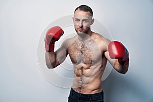 Muscular shirtless man wearing box gloves ready to struggle