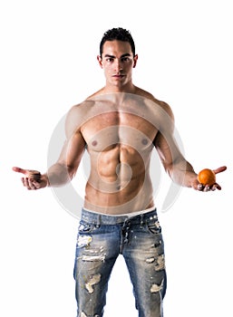 Muscular shirtless young man deciding: fruit or cookies photo