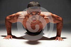 Muscular, shirtless young man doing press-ups