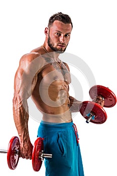 Muscular shirtless young man exercising biceps with dumbbells