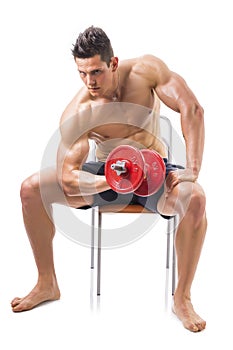 Muscular shirtless young man exercising biceps
