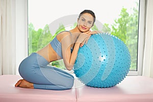 Muscular slim attractive female, flat belly perfect body. Beautiful fit woman doing yoga exercises with fitness pilates blue ball