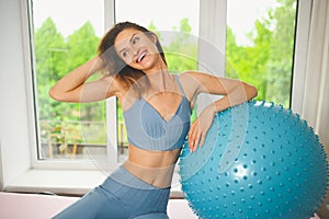 Muscular slim attractive female, flat belly perfect body. Beautiful fit woman doing yoga exercises with fitness pilates blue ball