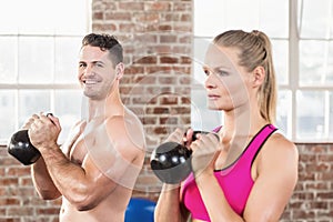 muscular smiling couple with kettlebells