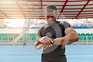 Muscular sportsman having a rest, he working out outdoors