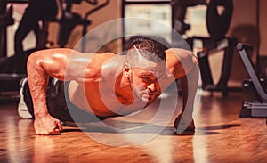 Muscular and strong guy exercising. Slim man doing some push ups a the gym. Man doing push-ups. Muscular man doing push