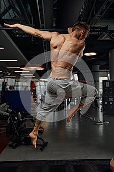 Muscular strong man exercising in the sport gym, Man doing horizontal push-ups with bars in gym. Background gym with