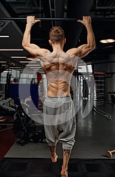 Muscular strong man exercising in the sport gym, Man doing horizontal push-ups with bars in gym. Background gym with