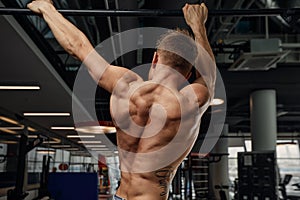 Muscular strong man exercising in the sport gym, Man doing horizontal push-ups with bars in gym. Background gym with