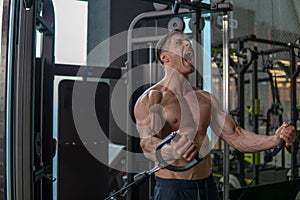 Muscular and strong man workout his chest and shoulders in the gym