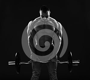 Muscular strong men, athlete, bodybuilder, weightlifter does exercises for top and arms, working out with barbell