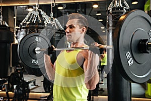 Muscular strong sportsman lifting barbell