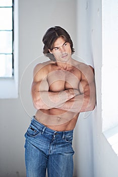 Muscular suntanned guy in denim jeans.