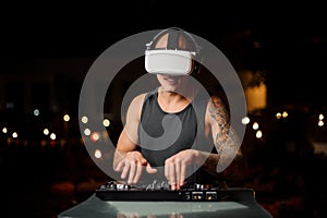 Muscular and tattooed nightclub DJ in night vision glasses