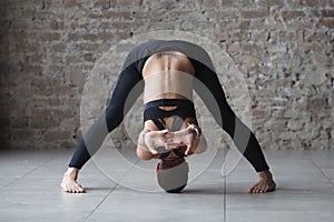 Muscular woman doing yoga indoor