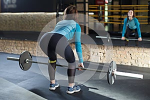 Muscular woman in a gym doing deadlift